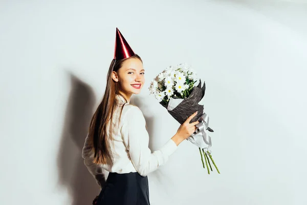 Söt flicka som håller en bukett blommor. Vackra vita prästkragar. Grattis på födelsedagen. Isolerad på vit bakgrund. — Stockfoto