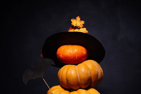 Halloween ristade pumpor i en svart häxa hatt står ovanpå varandra — Stockfoto