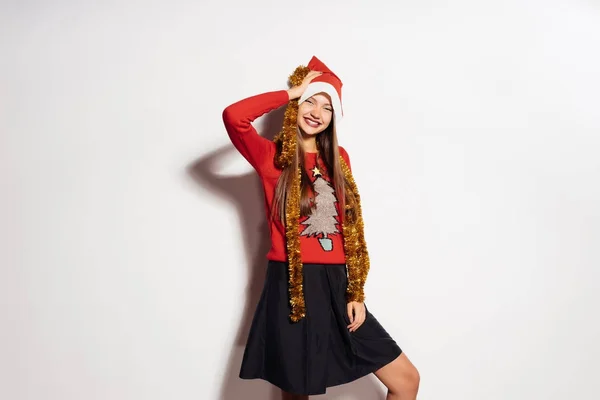 Smějící se dívka v novoroční čepici a s slavnostní pozlátko na krku — Stock fotografie