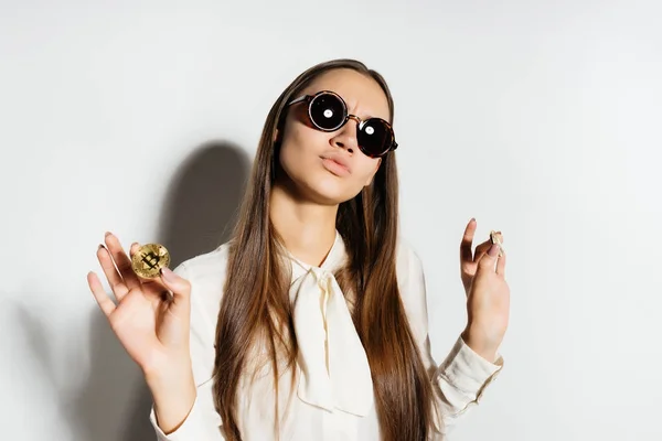 サングラスの現代少女はゴールド bitcoin、暗号通貨を保持しています。 — ストック写真