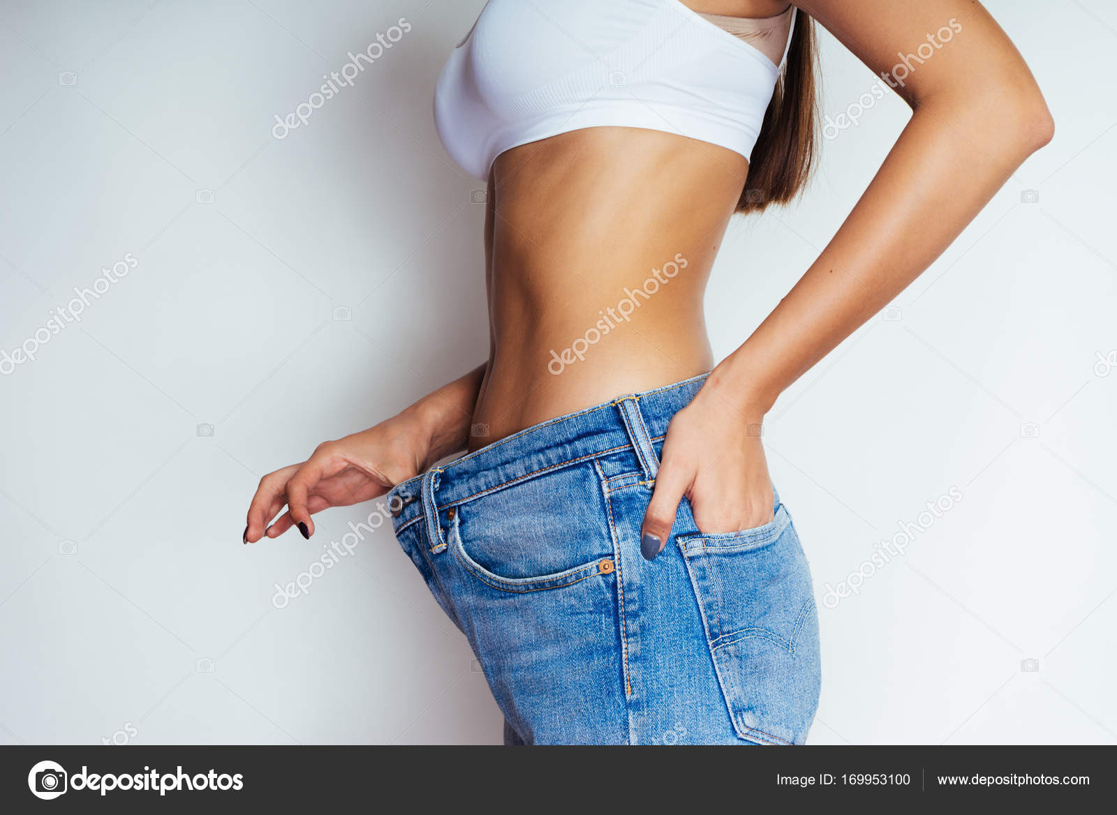A young athletic girl shows her flat stomach, quickly lost weight