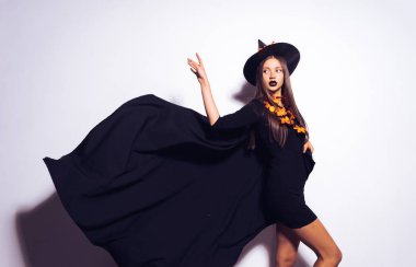 Giyimli genç bir Gotik kadın bir cadı olarak Cadılar Bayramı için siyah bir şapka taktı