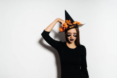 bir cadı Cadılar Bayramı için büyük bir siyah şapka taktı giyinmiş bir gülen kız