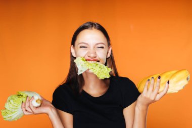 genç bir kız bir diyet oturur, gülüyor, ellerindetutan ve Pekin lahana ağız