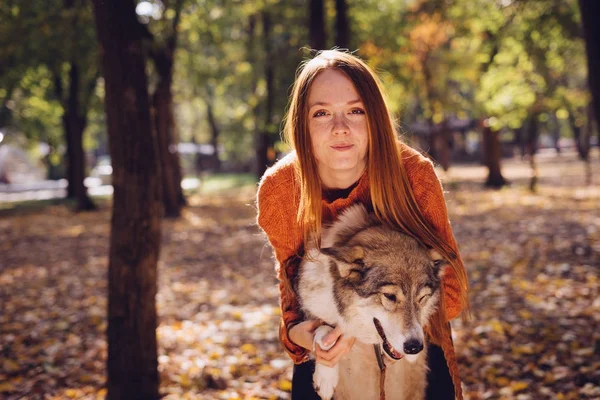 Kızıl saçlı kız köpeğini ile sonbahar park poz