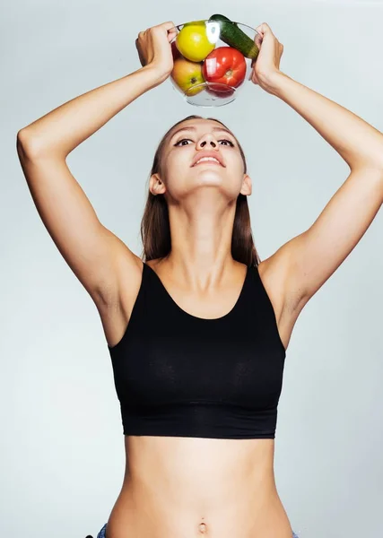 Sportovní dívka úsměvy, sedí na dietu, drží desku s zeleniny a ovoce ve svých rukou — Stock fotografie