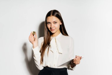 Kripto para birimi eğitim altın bir bitcoin ve bir tablet tutan genç gülümseyen iş kadını