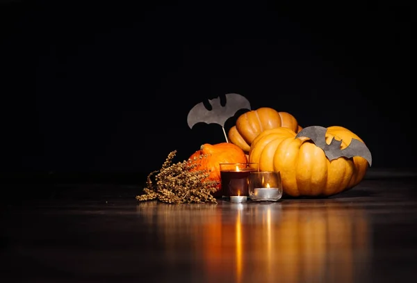 Sammansättning för att dekorera huset för halloween, gult och orange pumpor, brinnande doftljus, teckningar av svarta fladdermöss — Stockfoto
