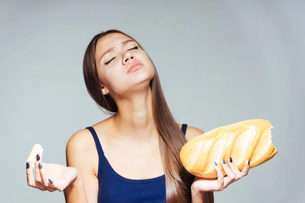 Hungriges Mädchen ernährt sich, isst aber schädliches Weißbrot — Stockfoto