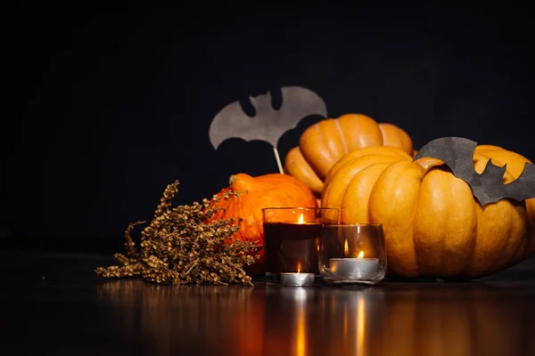 Composição para decorar uma casa para halloween, abóboras amarelas e laranja, velas em chamas, desenhos de morcegos pretos — Fotografia de Stock