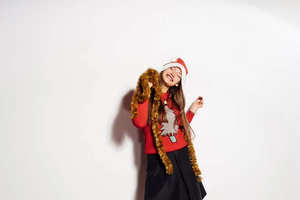 Gelukkig vrolijke meisje viert Nieuwjaar en Kerstmis, in een feestelijke trui en goud tinsel op de hals — Stockfoto