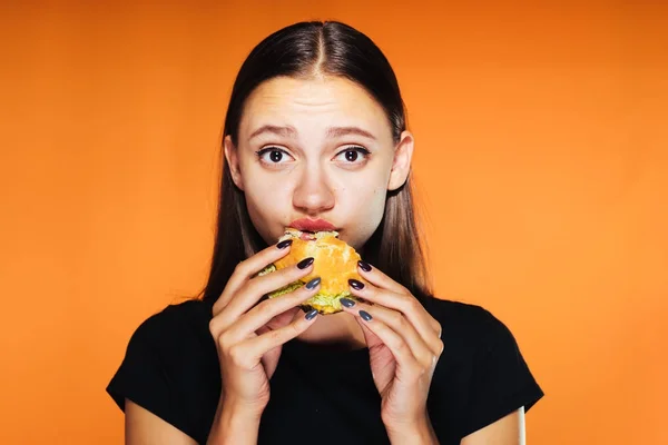 Mladá dívka chtěla zhubnout, ale žere škodlivé hamburger — Stock fotografie