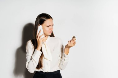 Altın bitcoin tutarak ve telefonda konuşurken genç iş kadını