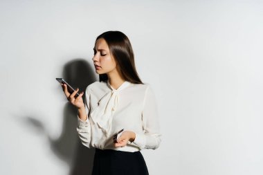 onun smartphone bakarak ve bir banka kartı tutan genç modern iş kadını