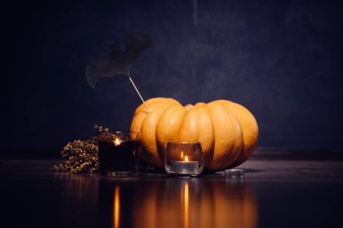 Cadılar Bayramı için bir ev dekorasyon için kompozisyon yalan kokulu mumlar yanan sarı ve turuncu kabak, 