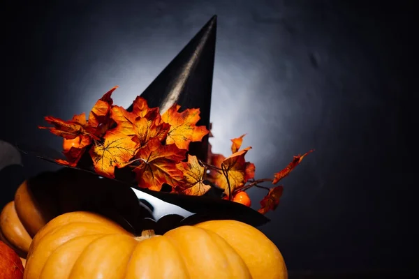 En komposition för att dekorera ett hus för halloween, orange och gult pumpor, en svart häxa hatt — Stockfoto