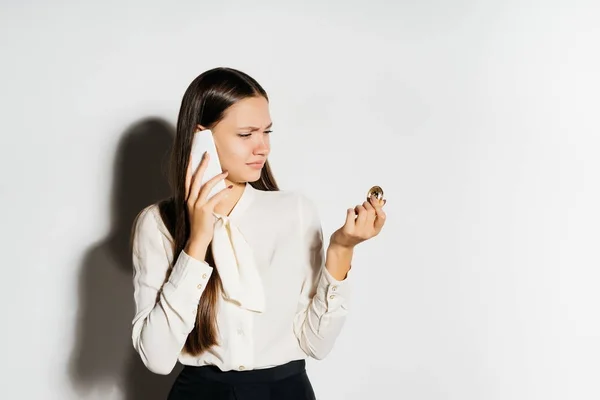 Jovem mulher de negócios segurando um bitcoin dourado e falando ao telefone — Fotografia de Stock