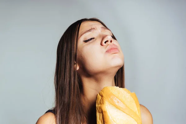 Głodny smutna dziewczyna chciała schudnąć, ale zjada szkodliwych białe pieczywo — Zdjęcie stockowe