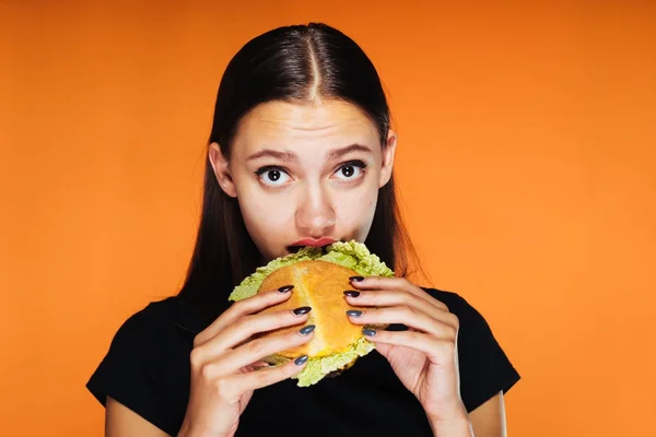 Frustrovaný dívka chce zhubnout, ale jí škodlivé hamburger — Stock fotografie