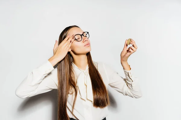 Joven mujer de negocios moderna en gafas mira bitcoine oro — Foto de Stock