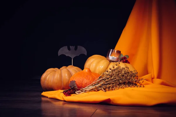 Sammansättning för att dekorera ett hus för halloween, ligga gula och orange pumpor, brinnande aromatiska ljus, röda bär — Stockfoto