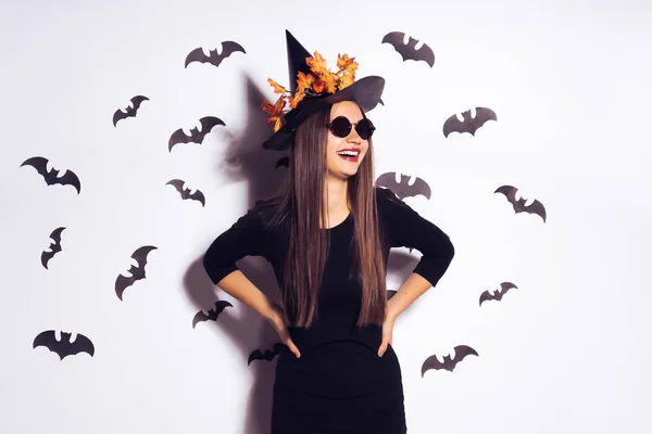 Jeune fille sexy souriante à l'image d'une sorcière à Halloween, sur les dessins muraux de chauves-souris noires — Photo