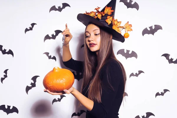 Hermosa chica gótica sexy en la imagen de una bruja en un halloween sosteniendo una calabaza en sus manos —  Fotos de Stock