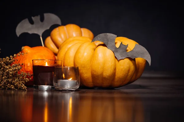 Une composition pour décorer une maison pour Halloween, citrouilles jaunes et orange, brûler des bougies parfumées — Photo