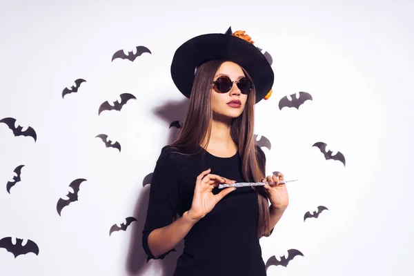 Bella ragazza gotica sexy a immagine di una strega di Halloween che tiene in mano un pipistrello dipinto — Foto Stock