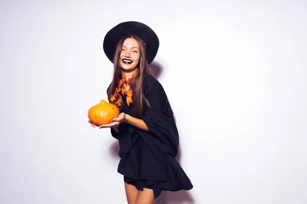 Gotické sexy dívka v obrázku čarodějnice slaví halloween, dýně drží ve svých rukou — Stock fotografie