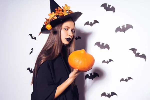 Jonge gotische sexy meisje in het beeld van een heks vieren halloween, houden een pompoen — Stockfoto