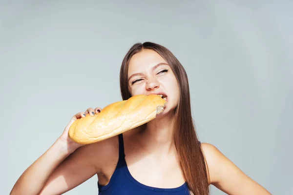 Jeune fille affamée veut perdre du poids, mange du pain blanc à haute teneur en calories — Photo