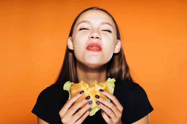 Fille affamée veut perdre du poids, mais mange avec impatience un hamburger nocif — Photo