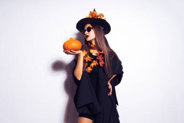 bir cadı, Cadılar Bayramı, kabak tutan sarı yaprakları ile süslenmiş büyük bir siyah şapka şeklinde bir genç güzel Gotik kız