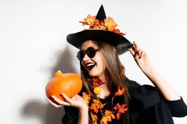 bir cadı, Cadılar Bayramı, kabak tutan sarı yaprakları ile süslenmiş büyük bir siyah şapka şeklinde bir genç güzel Gotik kız