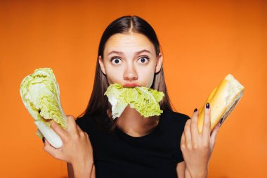 kızı tutan bir zararlı kalori hamburger ve yararlı Pekin lahana rejim, oturuyor