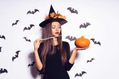 bir cadı, Cadılar Bayramı, kabak tutan sarı yaprakları ile süslenmiş büyük bir siyah şapka şeklinde bir genç güzel Gotik kız