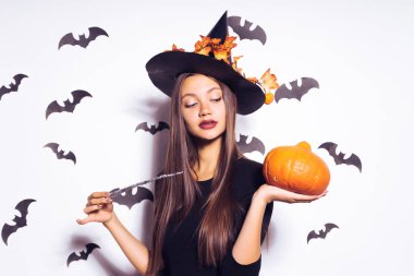 bir cadı, Cadılar Bayramı, kabak tutan sarı yaprakları ile süslenmiş büyük bir siyah şapka şeklinde bir genç güzel Gotik kız