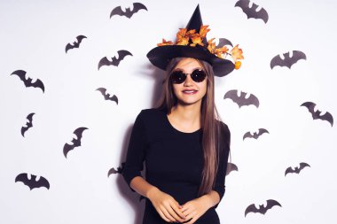 Gözlüklü Cool cadı. Siyah elbise ve şapka düşen yapraklar ile cadı. Cadılar Bayramı partisi kız. Cadılar bayramı kıyafeti, tatil.