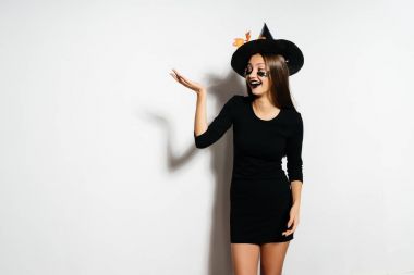 bir genç güzel bir cadı, Cadılar Bayramı, büyük bir siyah şapka şeklinde Gotik kız sarı yaprakları ile süslenmiş., 