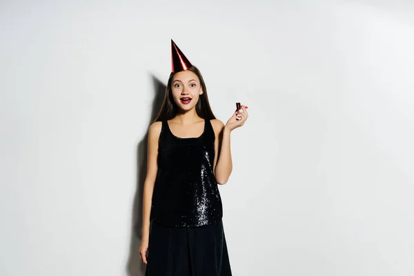 Chica joven se ve feliz, en su cabeza una gorra roja festiva — Foto de Stock