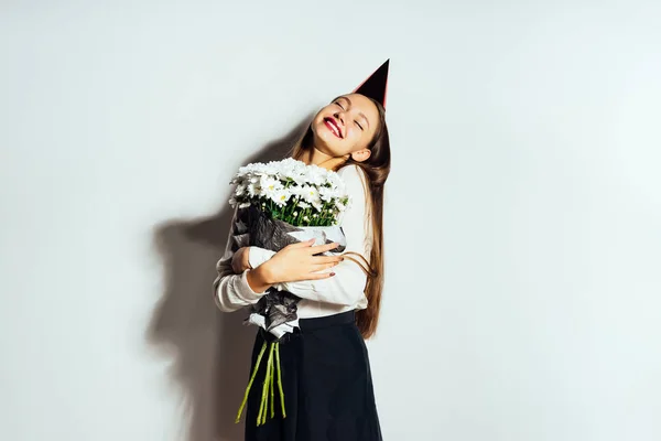 Uma jovem parece feliz, celebra algo, segura um grande buquê de flores brancas em suas mãos — Fotografia de Stock