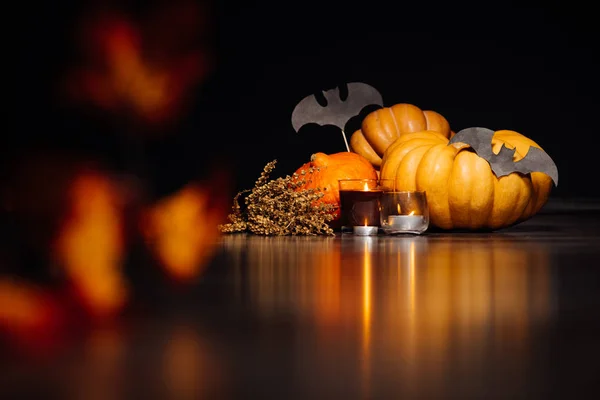 Grote Halloween pompoenen voor een feestje. brandende kaarsen, droge takken op een zwarte achtergrond. Halloween-feest, pompoenen — Stockfoto