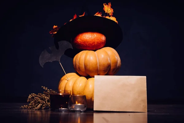 Dům dekorace pro Halloween, 3 dýně stojí přes sebe, čarodějnice klobouk, hořící svíčky, podzimní listí — Stock fotografie