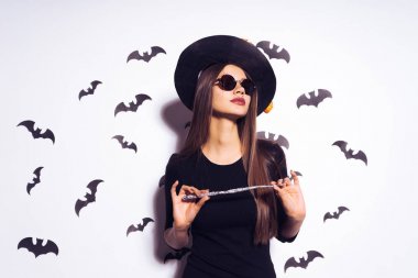 sevimli kız cadı Cadılar Bayramı partisi ve onun tutar için gidiş sihirli bir cadının değnek eller. Yarasalar birkaç arka planı