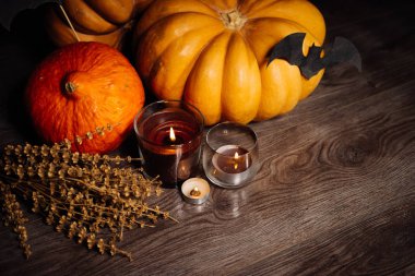 siyah bir zemin üzerine mumlar yanan Cadılar Bayramı için sonbahar altın yapraklarla kuru ot, büyük kabak