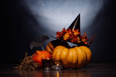sonbahar tatil, büyük balkabağı, bir siyah altın yaprağı cadı şapka, mumlar, kuru ot. Cadılar Bayramı, büyüleyici bir resim