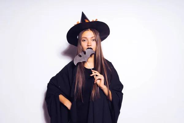 Ragazza strega di Halloween in un bel vestito nero è in possesso di un pipistrello sul suo bastone. La ragazza alla festa di Halloween. Festa di Halloween . — Foto Stock