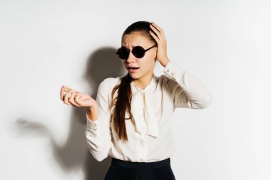 güneş gözlüklü genç kız kızgın görünüyor, altın bitcoin onun elinde tut