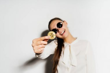 altın sikke yakın çekim. Kız bardaklarda bir sikke gösterir. Para, elektronik para, kripto para birimi